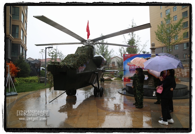 小區(qū)突然出現(xiàn)“飛機(jī)坦克”，其中殲15艦載戰(zhàn)斗機(jī)一架、99式主戰(zhàn)坦克一輛、武直-10武裝直升機(jī)一架，吸引了眾多市民雨中圍觀、合影。